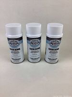 Three white aerosol cans of Dakota Odor Bomb Total Release Odor Eliminator with labels visible.