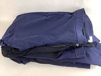 Folded plus size women's pants stacked showing navy blue and black colors.