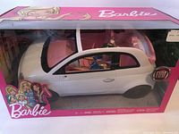 Barbie Fiat 500 convertible toy car in original pink packaging, white car body with pink interior and Fiat badge visible, Barbie doll inside as driver