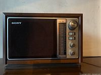 Front view of retro Sony wooden radio with speaker on left and control panel on right.