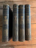Four volumes of Plutarch's Lives by Langhorne, with decorative gilt spines in dark blue cloth binding, showing titles and volume numbers.