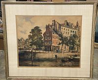 Full view of the framed artwork showing the cityscape with buildings, trees, and a water body with boats.