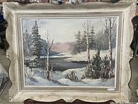 Framed oil painting showing full winter river scene, snow and trees.