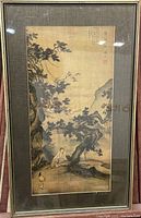 The full front view of the framed artwork, depicting monks beneath large gnarled trees in a mountainous setting, signed with Asian characters and red seals.