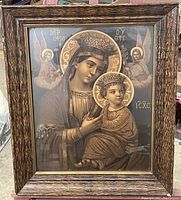 Photo of framed vintage religious artwork depicting Virgin Mary and child Jesus with angels in the background.