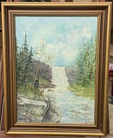 Framed vintage oil painting showing full scene with waterfall, trees and rocks, signed lower left.