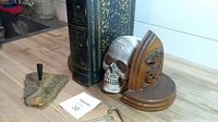 Photo of the maple bookends with eagle carvings, treasure book, skull figurine, and cork puller on a wooden surface