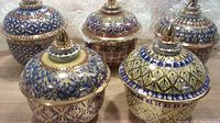 Photo showing all five large hand-painted Thai ceramic trinket boxes with lids arranged together, displaying intricate multicolor patterns and gold accents.