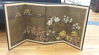 Full view of the three-panel folding screen showing floral painted artwork on a gold background with wood frame and fabric border