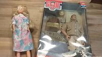 Photo of John F. Kennedy GI Joe action figure in original box alongside Pregnant Barbie doll.