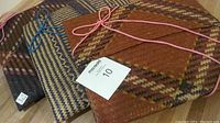 Three hand-woven bamboo sticky rice gift envelopes tied with colored cords, showing pattern and textures.