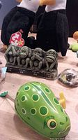 Close-up of the tin frog figurine, three wise monkey statue, and two eagle beanie babies.