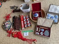 Overview photo showing most items including chopsticks, decorative hanging, calligraphy set, porcelain bowls, and white planter.