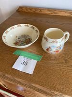Photo of the Bunnykins bowl and mug displayed together on a wooden surface with auction lot number visible.