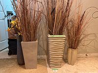 Four decorative ceramic planters with dried floral foliage, showing arrangement and sizes.