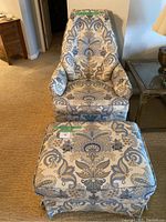 Front view of armchair with matching ottoman in cream, blue, and yellow patterned upholstery.