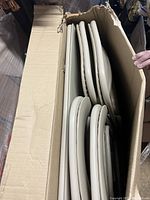 Stacked padded folding chairs inside cardboard box