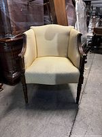Front view of the upholstered armchair showing wood frame and beige upholstery