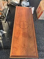 Full top view showing walnut wood grain and circular rosewood button inlay design at center of coffee table.