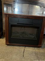 Front view of Heat Surge electric fireplace heater with wooden cabinet on wheels