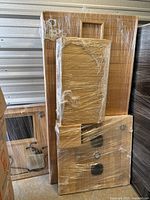 Overview of multiple shrink-wrapped wooden sauna panels stacked against wall