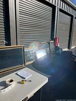 Photo of six mirrors lined up against a storage unit door, showing different frame styles and sizes.
