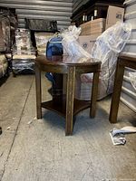 Full view of round table showing carved details and lower shelf.