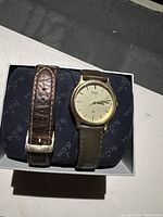 Seiko wristwatch with an extra leather band displayed in a box.