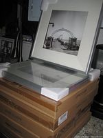 Stack of several new-in-box silver frames with foam corner protectors, showing the packaging and one displayed frame with photo insert.