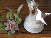Image showing green hummingbird on flower from front angle, focus on figurine details.