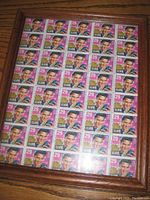 Full view of framed sheet displaying Elvis Presley postage stamps.