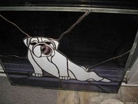 Full view of stained glass panel showing white bulldog with purple tongue on dark background.
