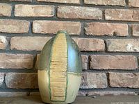 Front view of an Art Deco pottery vase with a central textured beige strip and green and beige matte glaze.