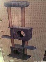 Full view of the multi-level cat tower showing its assembled structure with cubbyholes, platforms, and top perch.