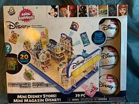 Box front showing the Mini Brands Disney Store with 39 pieces, 20 mini collectibles, and capsules.