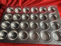 Top side view showing 24 shaped cups for baking muffin tops, metal pan in good condition.