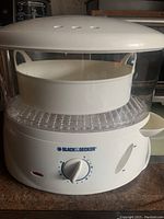 White Black & Decker electric food steamer with transparent lid and visible steaming basket inside.