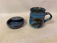 Photo showing the whole lot, including the blue glazed ceramic mug with handle and the matching trinket dish next to it.