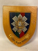 Full view of the wooden shield-shaped Black Watch wall plaque with banner and emblem.