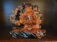 Front view of vintage burlwood clock showing natural irregular wood shape, clock face with hour and minute hands.