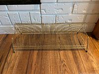 Front view of vintage metal LP storage rack showing multiple curved slots for records