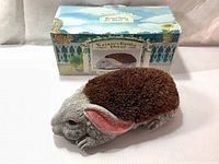 Front angle view of rabbit-shaped shoe scraper with original packaging box in background