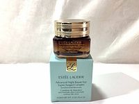 Front view of amber glass jar with gold lid, sitting on top of the retail box showing product name and details.