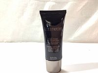 Front view of Laura Mercier Silk Creme Moisturizing Photo Edition Foundation black tube with silver cap, showing product name and details.