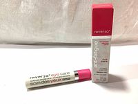 White Reversa eye care tube with pink cap next to the product box showing branding and volume.