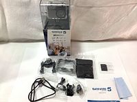 Full lot with camera inside packaging, accessories laid out on table