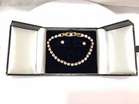 Top view of tennis bracelet and matching earrings displayed in black jewelry case