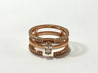 Front angle showing the open band rose gold tone plated ring with a central medium clear crystal and smaller clear crystals embedded along the bands.