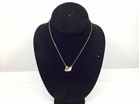 Full view of the Swarovski swan necklace displayed on a black stand showing pendant and chain length.