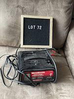Overview of Motomaster battery charger unit showing label, power cord, and clamps.